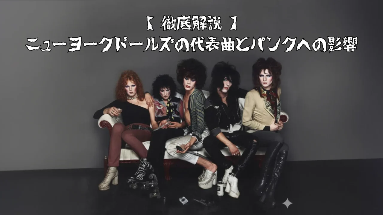 ソファに座った5人のロックバンド風の人物たちが、派手なメイクと個性的な衣装を身にまといポーズを取っている写真。背景は無地のグレー。