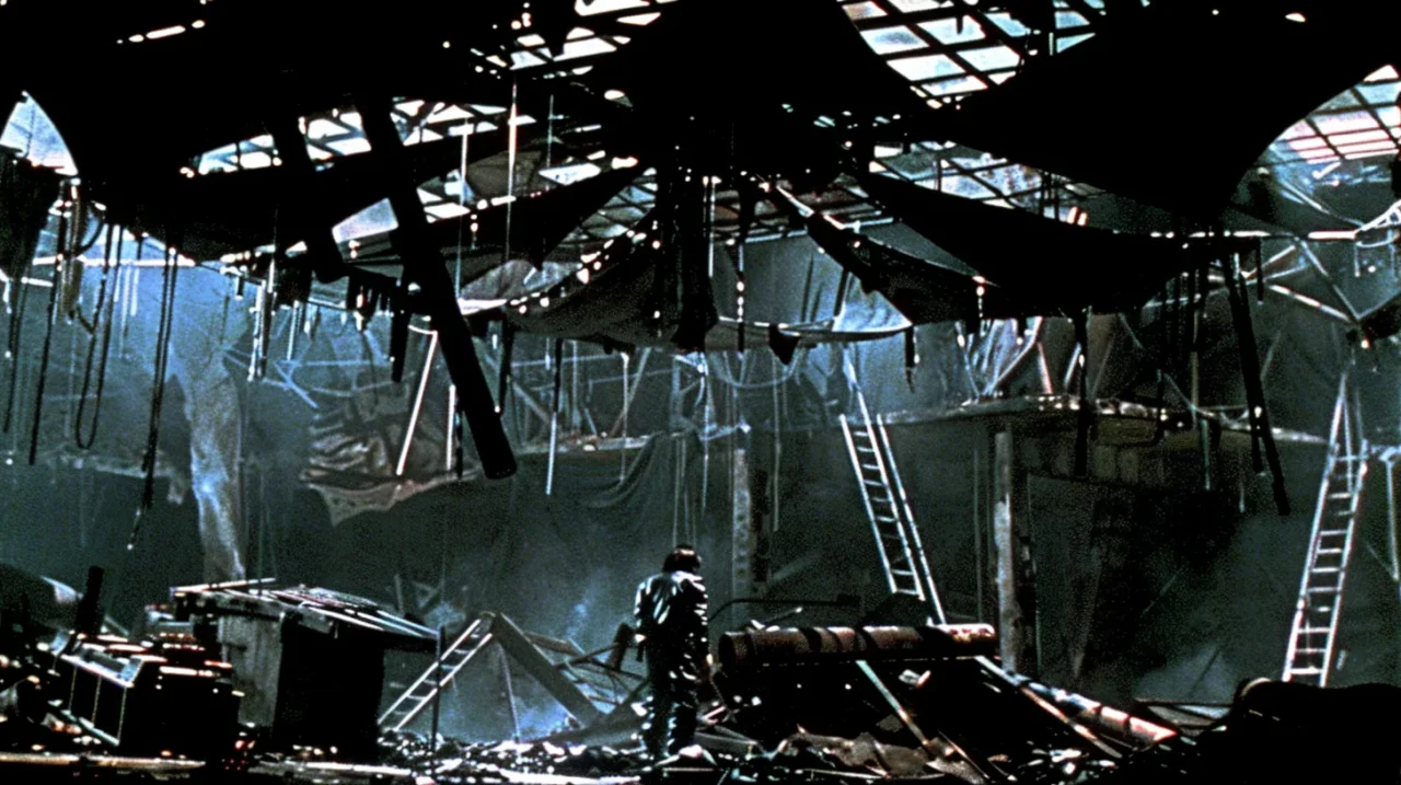 崩れ落ちた工業廃墟の内部に、一人の人物が立つディストピア的な風景の写真