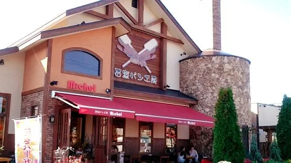 石窯パン工房ミッシェルの花巻本店の外観。赤いオーニングと石窯の煙突が特徴的なおしゃれな建物。